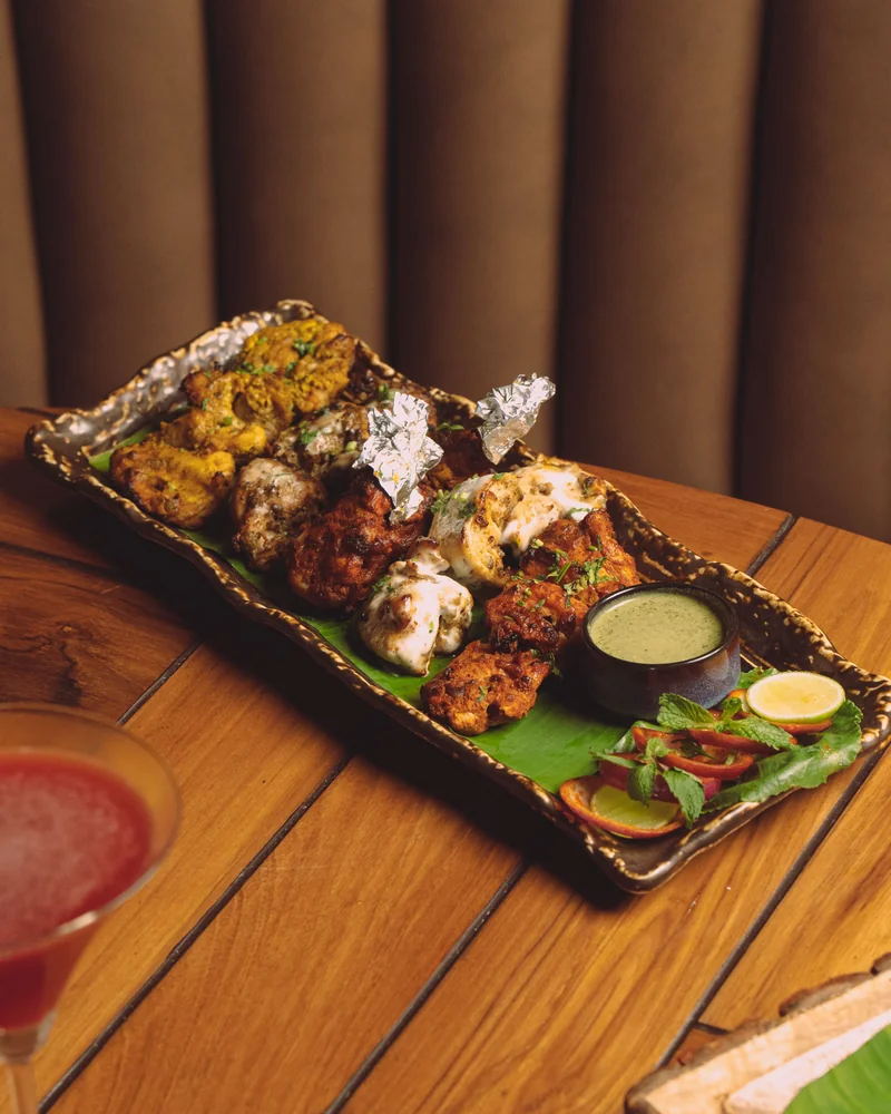 Grilled meat skewers with sauce and vegetables